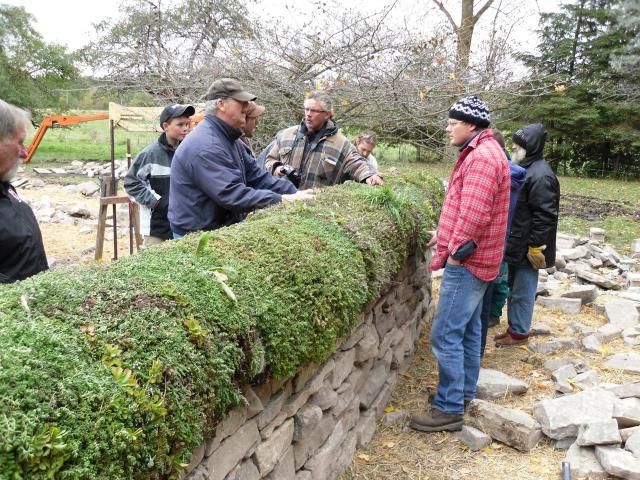 Mathis Natvic discusses with students the merits of sedum mat material for topping dry stone walls